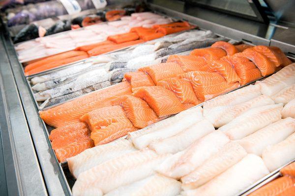 Tight shot of seafood case displaying cuts of fish.