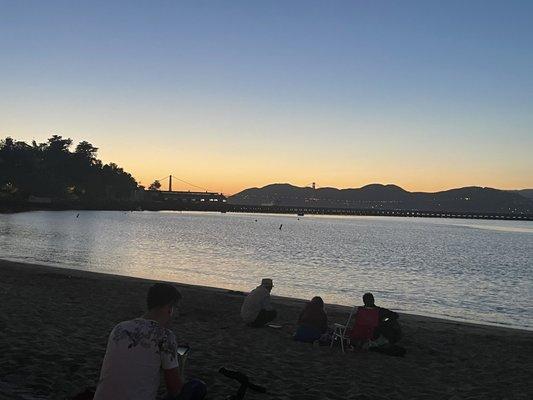 Guy with a guitar playing music sitting on the beach