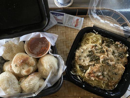 A side of garlic bread and chicken piccata dinner.