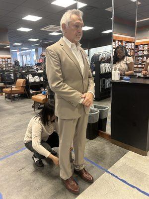 Tan suit pants being marked.