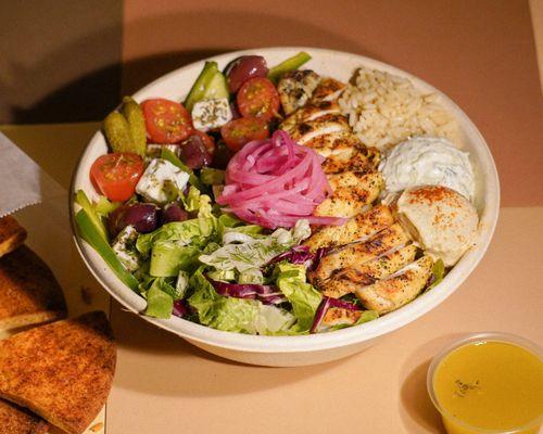 Charbroiled lemon chicken. Healthy Greek rice, green salad, Greek salad, hummus, dips and feta. pickled onions.