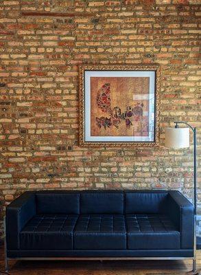 Couch and art with brick wall behind