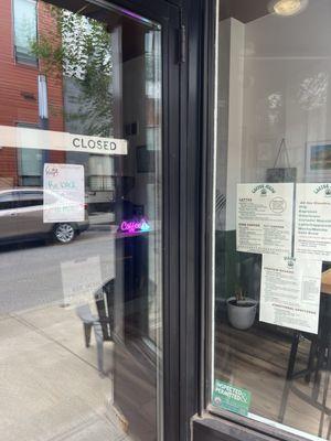 Hand written note stating 'back in 10' posted on the door. Menus containing coffee drinks and treats posted in the window.