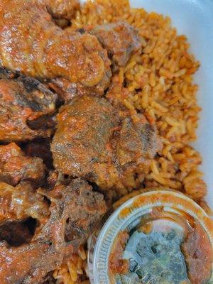 Jollof rice with meat and a side of spinach