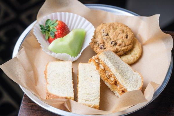 The Little Monkey Plate: peanut butter, honey, & bananas on a crustless potato bread served with fruit, cookies & a small drink.