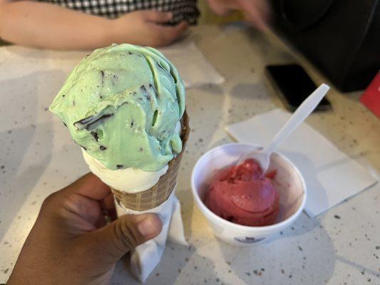 Double scoop of ice cream one white pistachio one mint and chip on a waffle cone