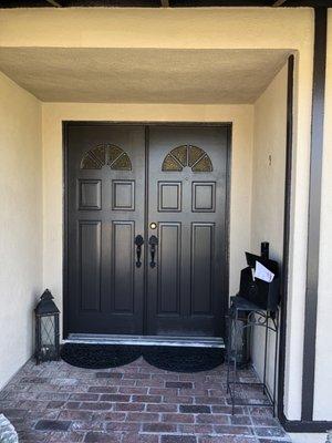 Front door of newly painted house using trim color