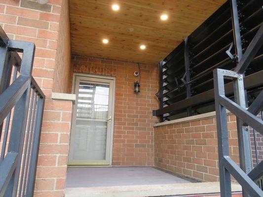 Side Deck with cedar slat ceiling with 4 over head can lights, custom louvers and composite decking with picture frame