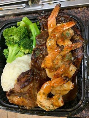 Grilled ribeye steak with shrimp served with garlic mashed potatoes and broccoli