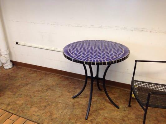 Near vending machine. Secluded area with one table, two chairs and a wall strip of a dozen outlets.