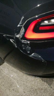 Pre-repair, angle 2 - cracked tail light, paint damage, cracked bumper.