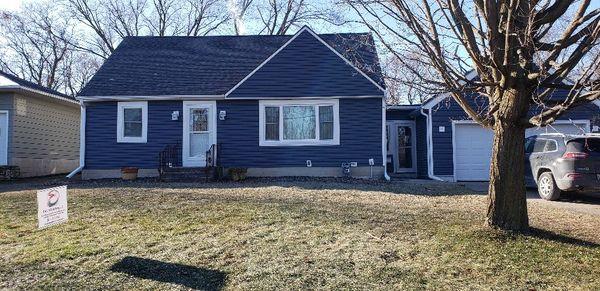 Siding, fascia, soffit, gutters, entry doors, storm doors, and windows with new wraps on this house in Hartford.