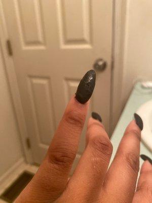 chipped, matte black acrylic nail polish