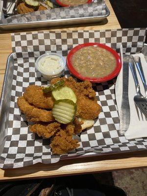 Chicken tenders with ranch dipping sauce and beans as a side