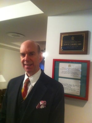 Dr. Vogel in front of a wall of honors and awards.