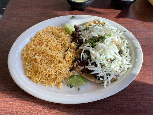 One steak taco, one pastor taco, and side or arroz