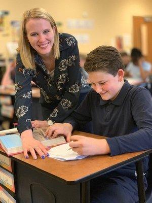 Friendly teacher guides studying boy