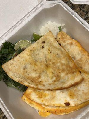 El pastor quesadilla with lime wedges and fresh cilantro/onion