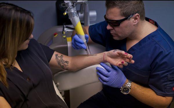 Ryan Wright, BBA, BSN, RN - Founder of Ink Blasters LLC conducting a laser tattoo removal treatment in Detroit Michigan.