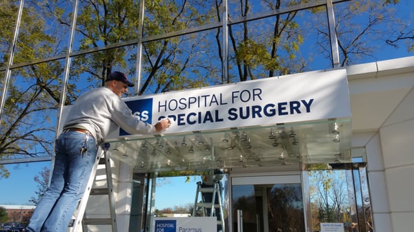 Our employee hard at work installing a sign for Hospital For Special Surgery!