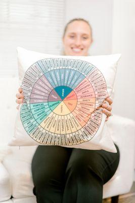 Our counselor holding her feelings pillow that helps patients dive deeper into their emotions.