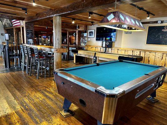 Pool table and shuffle board in bar area.