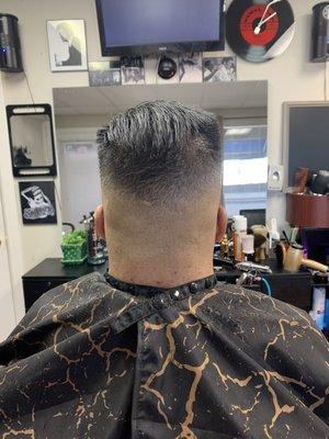 Mid-High fade with slick back hair style.