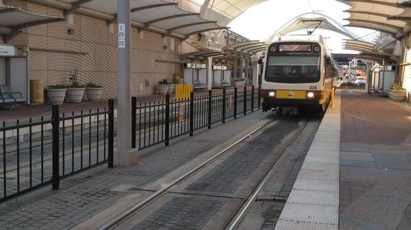 A light rail train is approaching the DFW station.