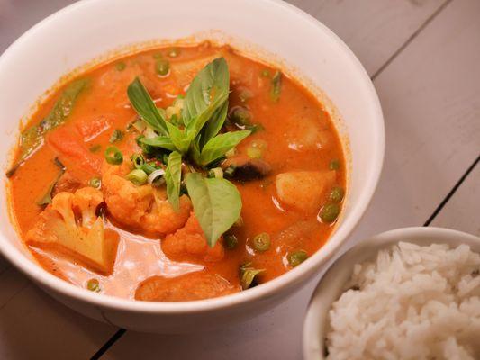 Spicy red curry with vegan chicken: A delightful dish featuring cubes of vegan chicken, potatoes, carrots, shiitake mushrooms, cauliflower,