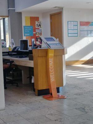 The kiosk that needs to be moved to the front of the desk when no one is there.