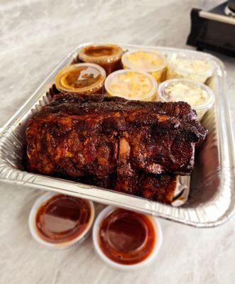 Full rack of ribs cut in half with two sides of coleslaw two sides of mac & cheese, and two sides of beans