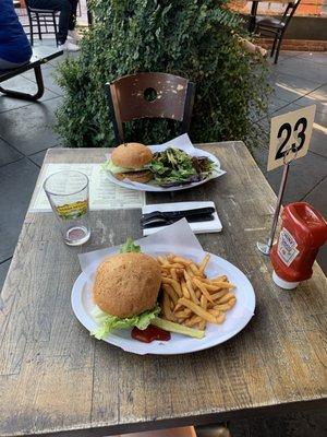 Patio, burgers, fries and a salad.