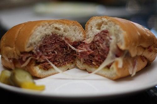 pastrami topped with melted cheese and spicy mustard on caraway rye