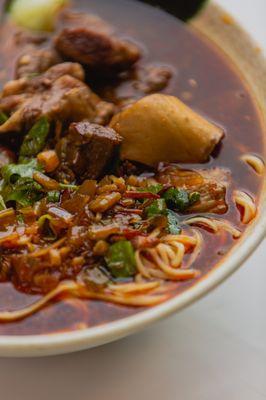 Authentic Spicy Beef Noodle Soup, featuring a rich savory broth that is made fresh, served with fresh handmade noodles.