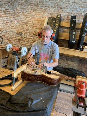 Student routing a bridge slot on his custom build guitar.