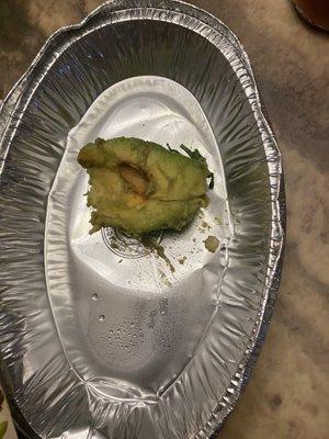 Unripened avocado with half a pit in it, instead of guacamole.