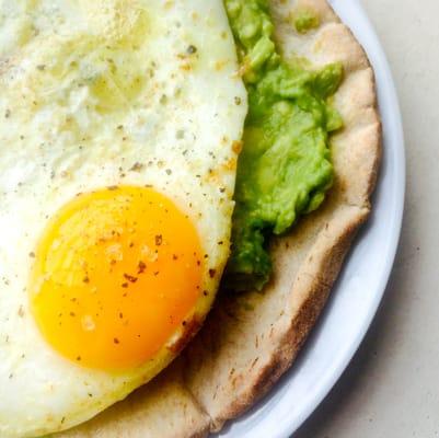 Slow fried egg on smashed avocado and whole wheat pita