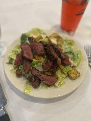 Small Caesar salad with medium rare steak