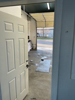 Inside small waiting area looking at the window tint garage bay.