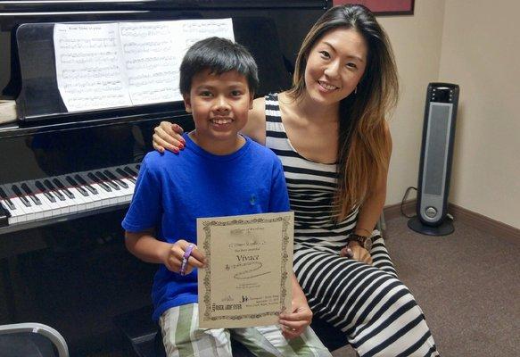 A proud student with his Musical Ladder certificate and wristband.