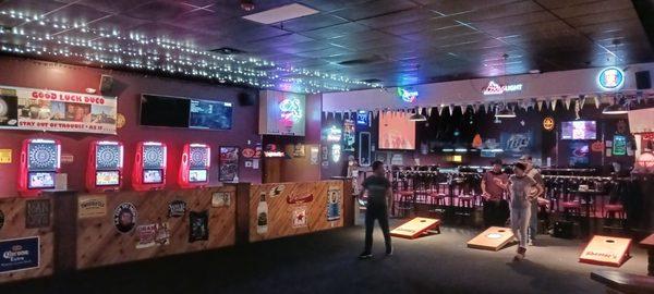 Bag toss area with dart board games in the background.