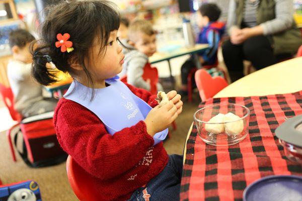 Caterpillars (2-2.8 years old) eating their lunch from home on their own. Microwaves in each classroom and teachers heat up food if needed