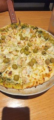 Custom sourdough crust, garlic chicken, GREEN olives on pesto sauce, with mozzarella and feta...yummo!