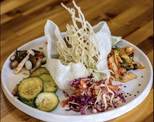 Buddha Plate. House made kimchi, Asian slaw, cucumbers, peanut sauce with rice  noodles, edamame hummus, and a mushroom salad. Delicious!