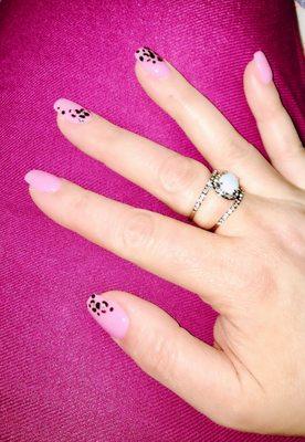 SNS on natural nails with leopard print design on edges of some fingers.