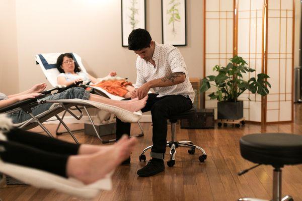 Christian performing acupuncture on a patient in the Community Room