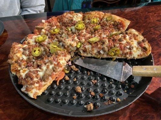 Hand tossed sausage, bacon, and jalapeños pizza.