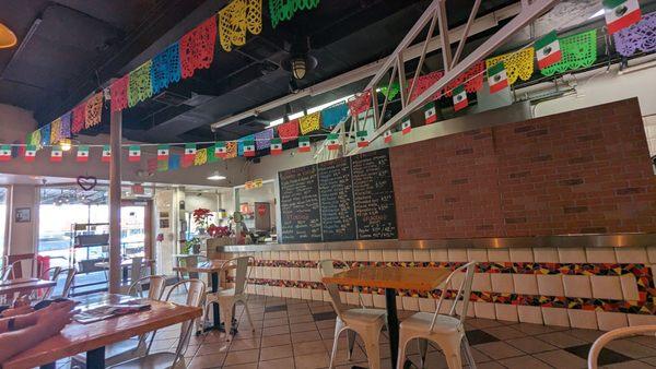 Few tables, colorful flags, nice clean dining room.