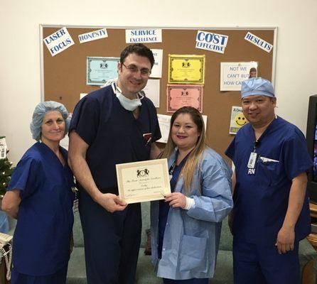 Dr. Entabi giving an award to Cathy, the OR coordinator along with Trena (operating room technician) and Carlito (Operating room Nurse) i