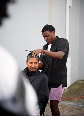 Isaiah owens (Crypto) cutting at a free haircut community event